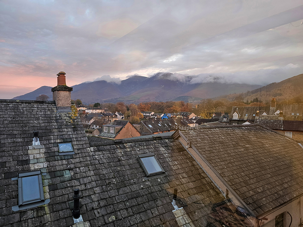 Keswick, sunrise over the rooftops and a view of Skiddaw, wreathed in clouds.